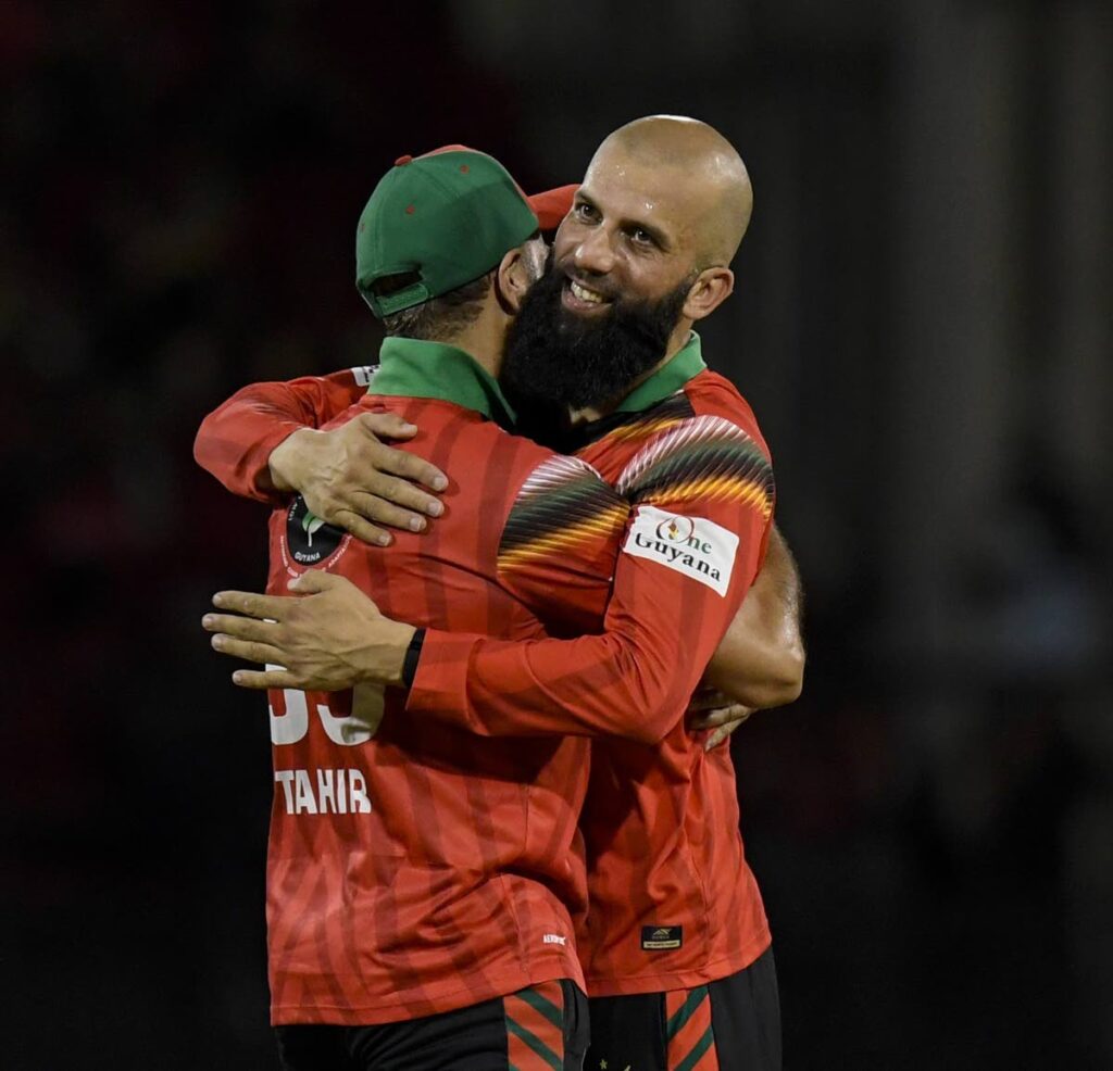 Moeen Ali, right, and Imran Tahir of Guyana Amazon Warriors celebrate a wicket vs Antigua and Barbuda Falcons in the Republic Bank Caribbean Premier League at Guyana National Stadium on September 21, in Providence, Guyana.  - CPL T20 via Getty Images