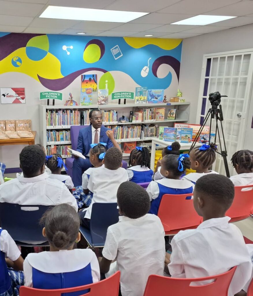 Laventille West  MP Fitzgerald Hinds reads to students at the Beetham Gardens Community Library. - 