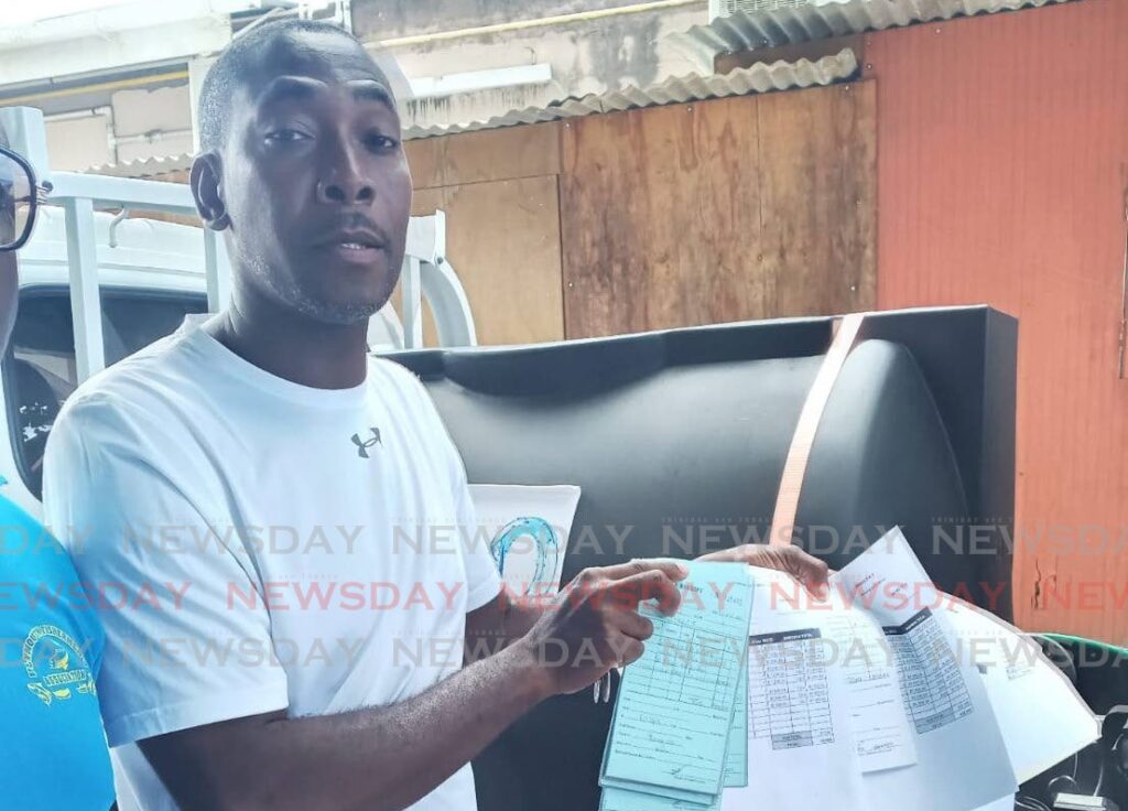 Contractor Allister Mc Clatchie shows reporters his bills at a news conference held at the Courland Fishing Facility on September 27. - Photo by Corey Connelly