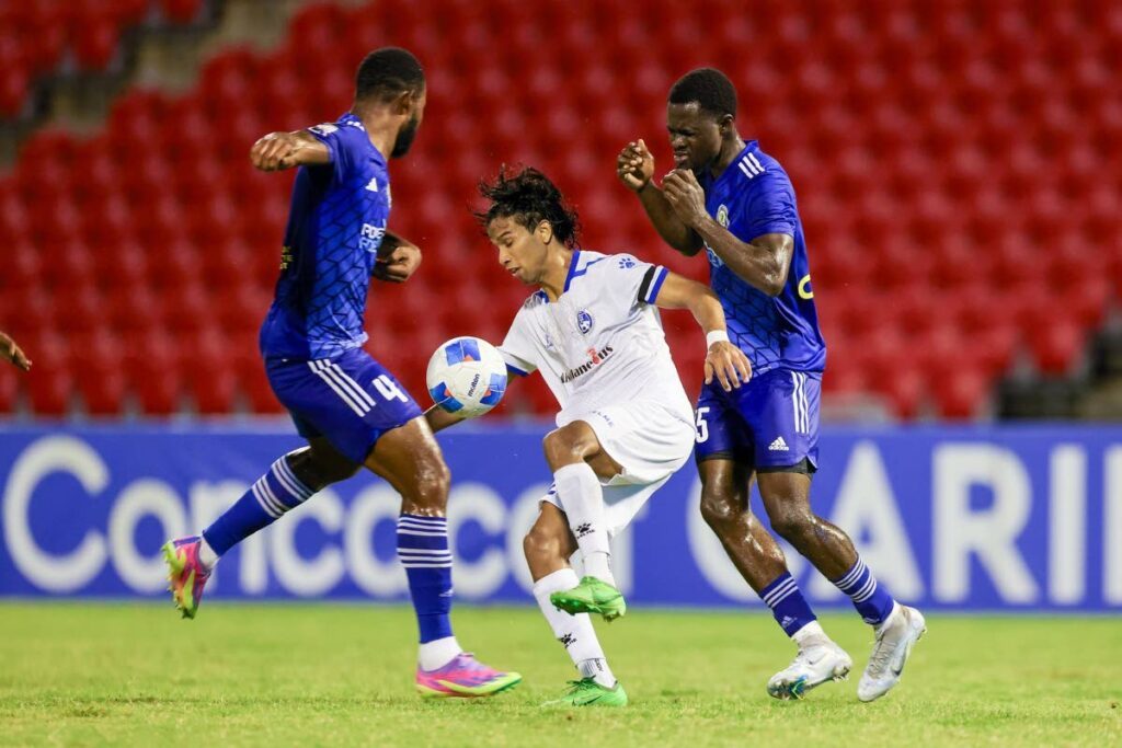 Miscellaneous Police FC midfielder Mark Ramdeen (C) takes on two Mount Pleasant Football Academy players during their Concacaf Caribbean Cup group A match at the Hasely Crawford stadium in Mucurapo on September 26. PHOTO COURTESY DANIEL PRETINCE/STRAFFONIMAGES - 