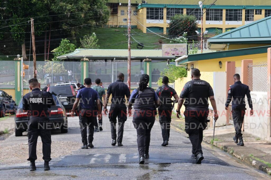 In this file photo, police officers walk outside the St Francois Girls' College in Belmont. - Photo by Roger Jacob