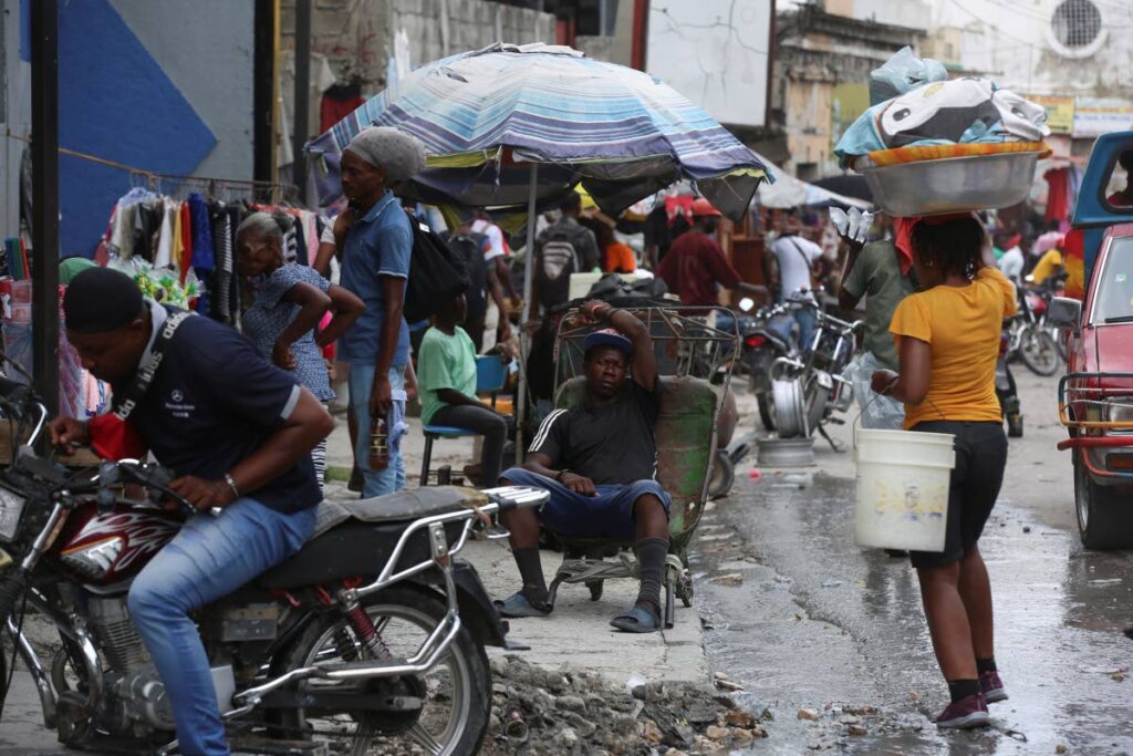 A man rests on a wheelbarrow on a street in Port-au-Prince, Haiti, last Monday. - AP