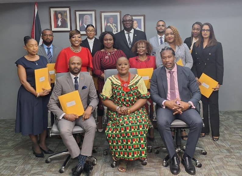 POSCCL board members appointed: (Sitting) Montgomery Guy, chairman, left; Camille Robinson-Regis, Minister of Housing and Urban Development; and Adrian Leonce, Minister in the Ministry. (Standing, row 1) Directors: Marilyn Lewis-Tobias, left, Belinda Charles, Rayann Williams-Gulston, Marilyn Michael, Sharon Felix, and Tersha Singh.  (Standing, row 2) Directors: Gary Ferdinand, left, Genève Simmer Mohammed, Lester Henry, Randy Sinanan and Aisha Kujifi.Photo courtesy Ministry of Housing and Urban Development. -