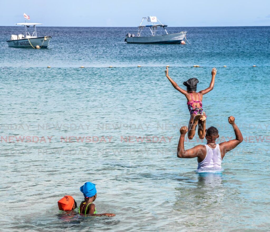 Visitor Paul Hospedales on vacation with his three daughters in Store Bay, Tobago. - File photo