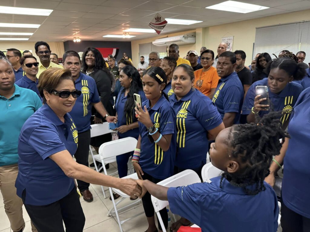 Opposition Leader Kamla Persad-Bissessar greets a young supporter at the party’s headquarters in Chaguanas on September 1 after a general elections preparation meeting. - Photo courtesy UNC