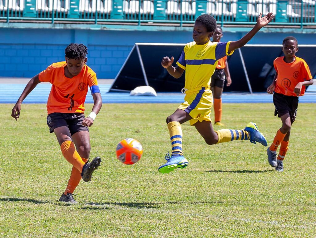 A player from Signal Hill Primary School (left) shoots past the aerial challenge of his Whim Anglican Primary School opponent, during the Boys Under-15 final of the Tobago Primary School Football League at the Dwight Yorke Stadium, Bacolet. - (FILE PHOTO)