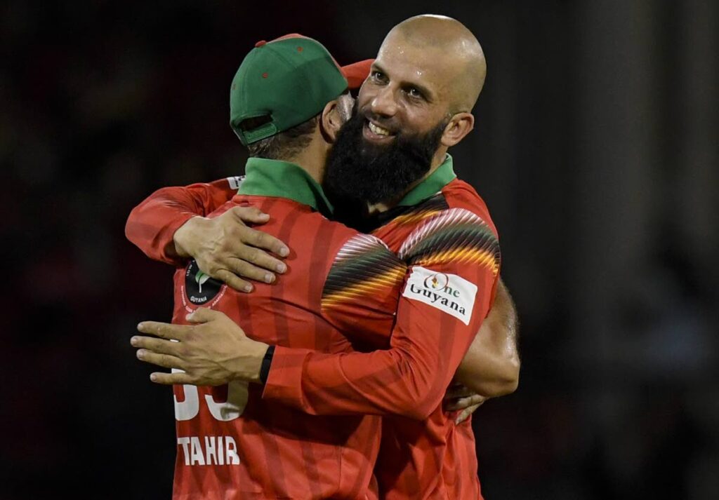 Moeen Ali (R) and Imran Tahir (L) of Guyana Amazon Warriors celebrate a wicket during the Republic Bank CPL. - Photo by Randy Brooks/CPL T20 via Getty Images