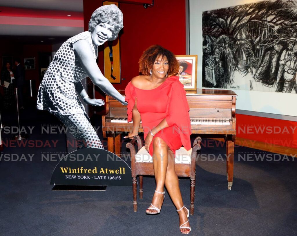 Charlene Griffith takes a photo with the childhood piano of pianist Winifred Atwell during commissioning of the Winifred Atwell Auditorium. - AYANNA KINSALE