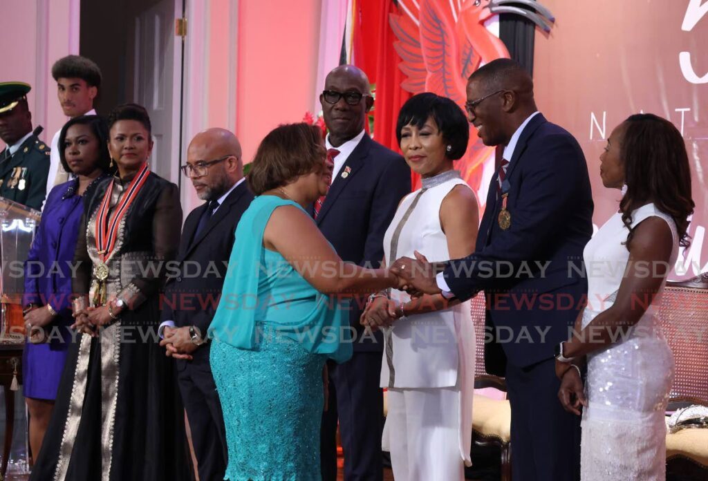 Rowena Martineau-Pitt is congratulated by Chief Justice Ivor Archie on receiving a national award for her work in the Development of Women.  - Photo by Roger Jacob