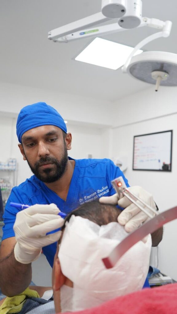 NEW HAIRLINE: Dr Emerson Budhoo uses laser tools on a patient for precise marking of the new hairline. Budhoo, a specialist in orthopaedic and trauma surgery, is the founder of Caribbean Hair Transplant, a hair restoration clinic based in Port of Spain. - 