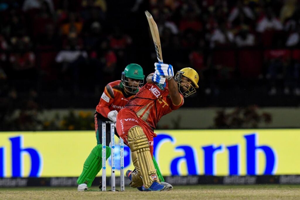 TKR's Nicholas Pooran hits  a six while Shai Hope (L) of Guyana Amazon Warriors looks on during the 2024 Republic Bank Caribbean Premier League match 30 at Guyana National Stadium on September 29, 2024 in Providence, Guyana.  - (CPL T20)