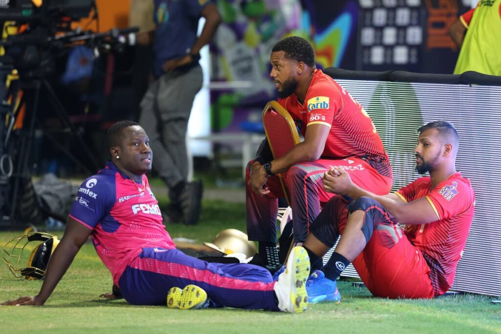 Barbados Royals skipper Rovman Powell (L) and the TKR pair of Chris Jordan (C) and Nicholas Pooran (R) wait as a faulty floodlight causes a delay in play during their 2024 Republic Bank CPL eliminator match at Providence Stadium, Guyana on October 1. - Photo courtesy CPL T20 