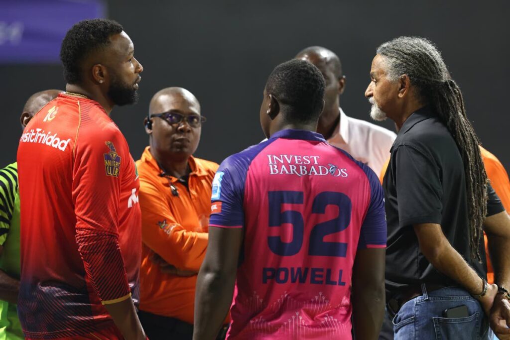 Captains Kieron Pollard, left, and Rovman Powell, centre, talk to CPL operations director Michael Hall, right, and other officials during a delay in play in the 2024 Republic Bank CPL eliminator match between Trinbago Knight Riders and Barbados Royals at Providence Stadium, Guyana on October 1. - Photo courtesy CPL T20 - 