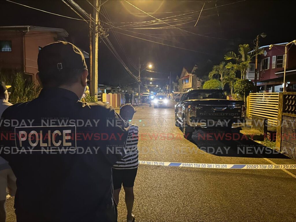 CRIME SCENE: A policeman stands guard near the scene of a shooting incident on Dookie Street in Penal on Wednesday night which left two men dead. - Photo by Rishard Khan 