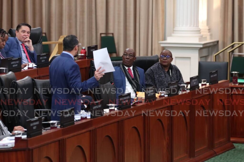 SAY WHAT? : The Prime Minister and Housing Minister Camille Robinson-Regis react as Energy Minister Stuart Young presents a copy of a fake document he says was submitted by a company to support its bid for the mothballed Petrotrin refinery. Young made his contribution to the budget debate in the House of Representatives on October 4.  - Faith Ayoung