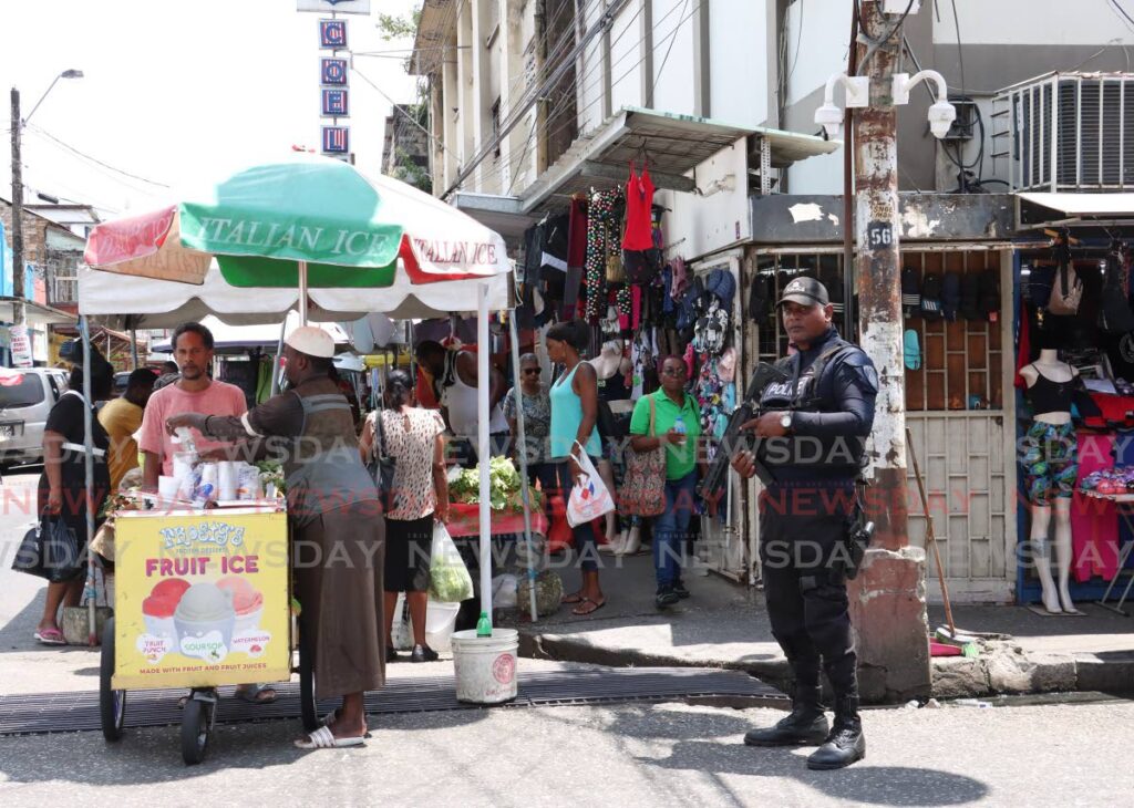 A police officer on patrol on Charlotte Street, Port of Spain on Friday.  - Photo by Faith Ayoung