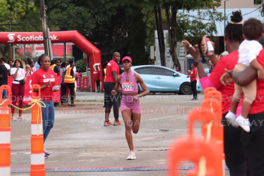 April Francis crosses the finish line to win the women's category of the Scotiabank Women Against Breast 5K at the Queen's Park Savannah, Port of Spain on October 5.  - Photo by Faith Ayoung