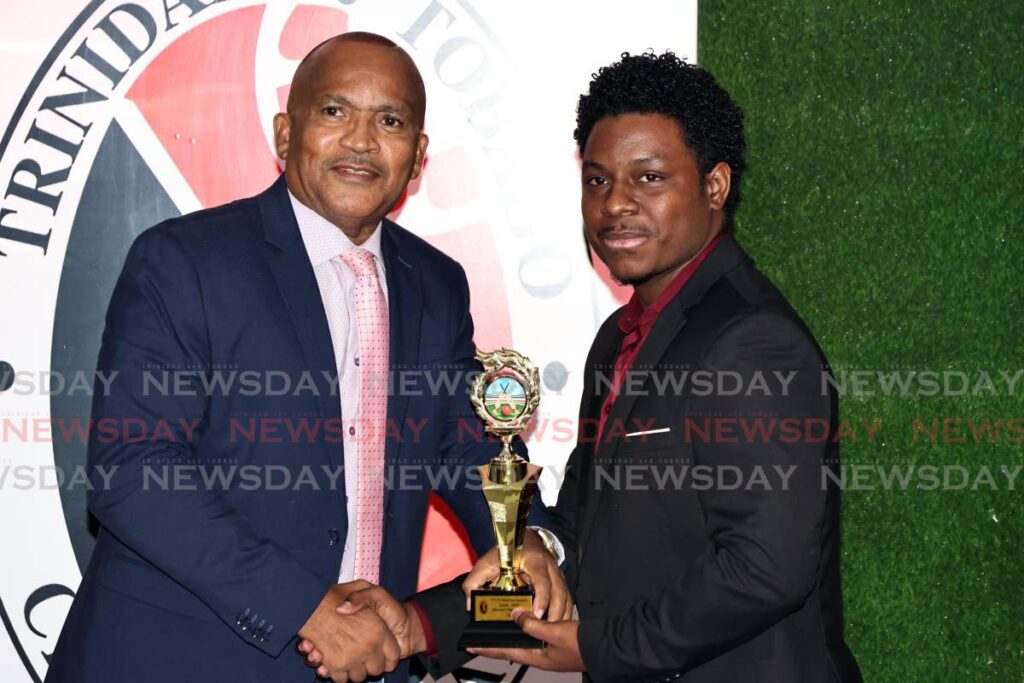 TTCB member Henry Chase, left, presents Jonte Thomas of Alescon Comets with the Reserve League MVP award for compeing in the premiership II division, South, at the TTCB awards ceremony at the Brian Lara Cricket Academy, Tarouba, October 5. - Photo by Lincoln Holder 