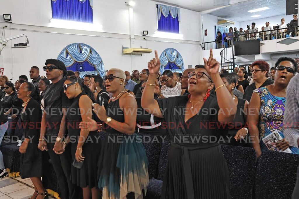 Mourners sing during the funeral for Cecelia Felix and her murdered son Gerald on October 7 at the Alpha Ministries Temple Beautiful church in Penal. - Photo by Lincoln Holder - lincoln Holder 