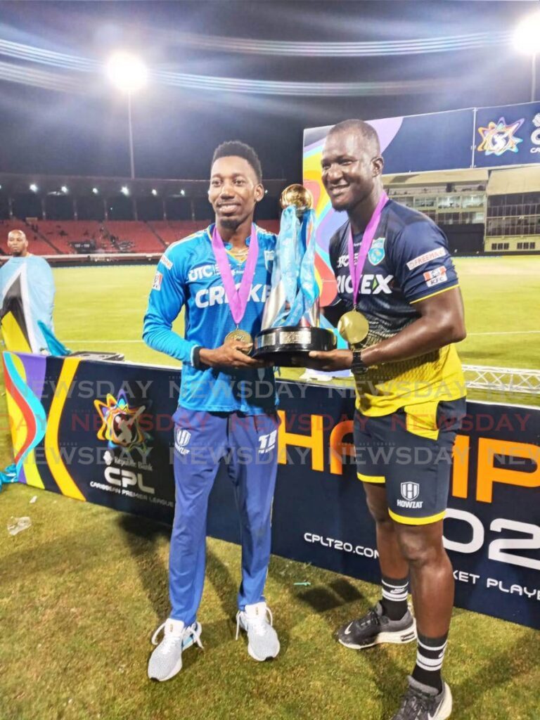 St Lucia Kings spinner Khary Pierre, left, holds the CPL trophy with Kings coach Daren Sammy. - Jelani Beckles