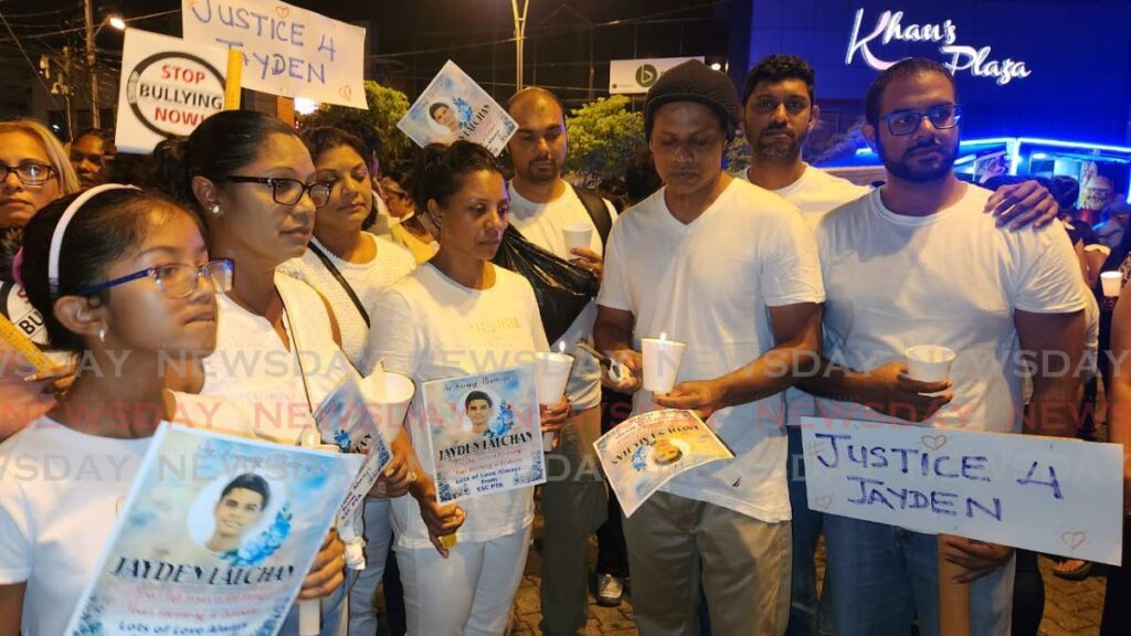 FOR OUR SON: Fareeda Lalchan, centre, and her husband Roshan, 3rd from right, during a candlelight vigil on Monday evening in Princes Town in memory of their son Jayden, 15, who died by suicide after enduring bullying at school. - Photo by Yvonne Webb 