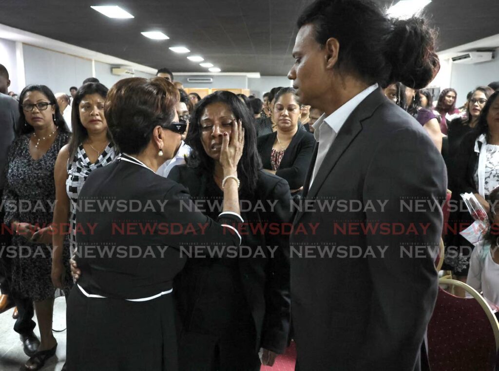 Opposition Leader Kamla Persad-Bissessar, centre, attempts to console Nelly Lalchan as her husband, Rohan Lalchan, looks on during the funeral for their son Jayden Lalchan, at the JR&D Convention Centre in Princes Town, October 8. - Roger Jacob