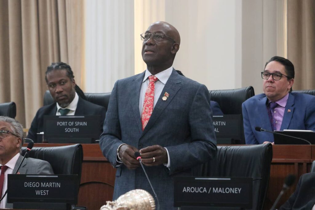 I'VE RUN THE RACE: Prime Minister Dr Keith Rowley during the budget debate on October 10 in the House of Representatives. At left is Laventille East/Morvant MP Adrian Leonce and Diego Martin Central MP Symon de Nobriga. PHOTO COURTESY OFFICE OF THE PARLIAMENT - 