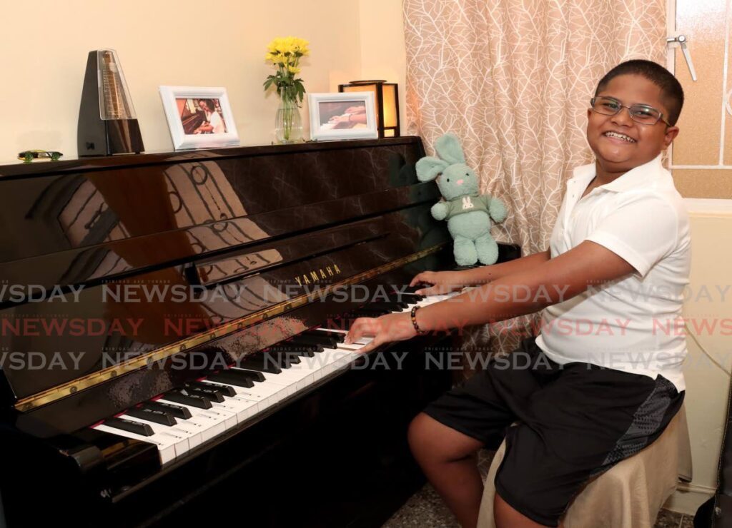 David Durham, 11, happily plays his Yamaha piano for Newsday. - Photo by Faith Ayoung