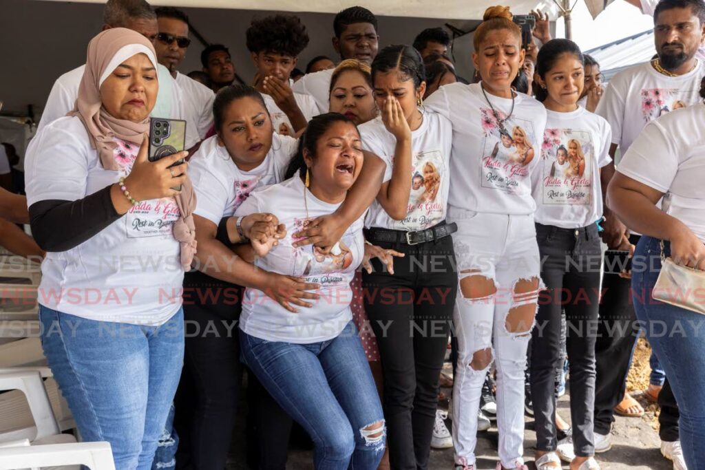 Jassodra Rajaram, sister of murder victim Tara Ramsaroop, is held back by family members upon the arrival of the bodies of Ramsaroop and her 14-month-old daughter, Shermaya 