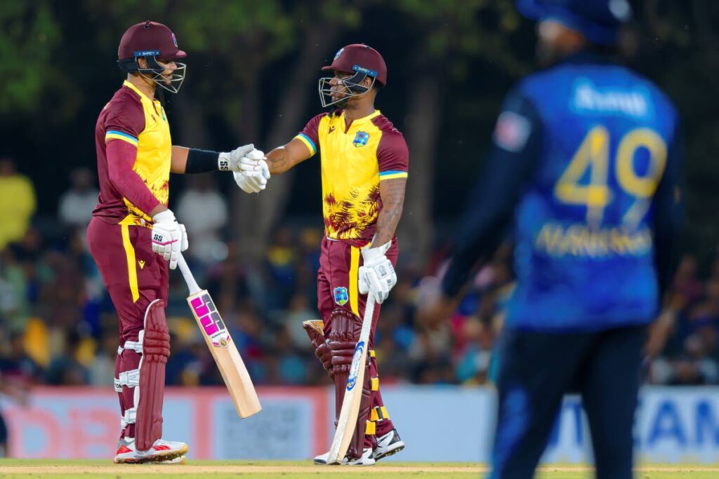 West Indies batsmen Brandon King, left, and Evin Lewis bump fists during the first T20 match between Sri Lanka and West Indies in Dambulla, Sri Lanka on October 13. - AP PHOTO