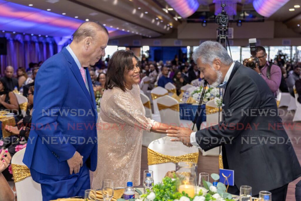 Minister of Trade Paula Gopee-Scoon is welcomed by SM Jaleel chairman Aleem Mohammed, right, at the company’s 100th Anniversary Long Service Awards, held at Achievers Banquet Hall on October 12. Also in the photo is former government minister Jerry Narace. - Photo by Jeff K. Mayers