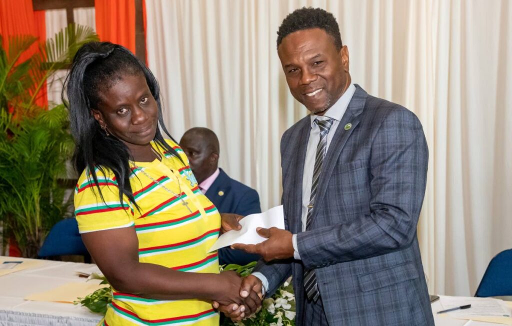 Division of Settlement assistant secretary Orlando Kerr, right, hands a recipient a cheque at a grant distribution ceremony on October 14. - Photo courtesy THA