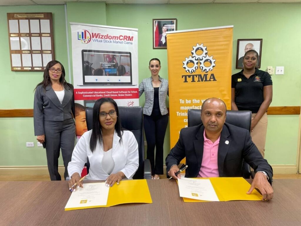 WizdomCRM country manager Charielle Plowden, left, and TTMA CEO Dr Mahindra Ramdeen sign a MoU.
Photo courtesy TTMA  - 