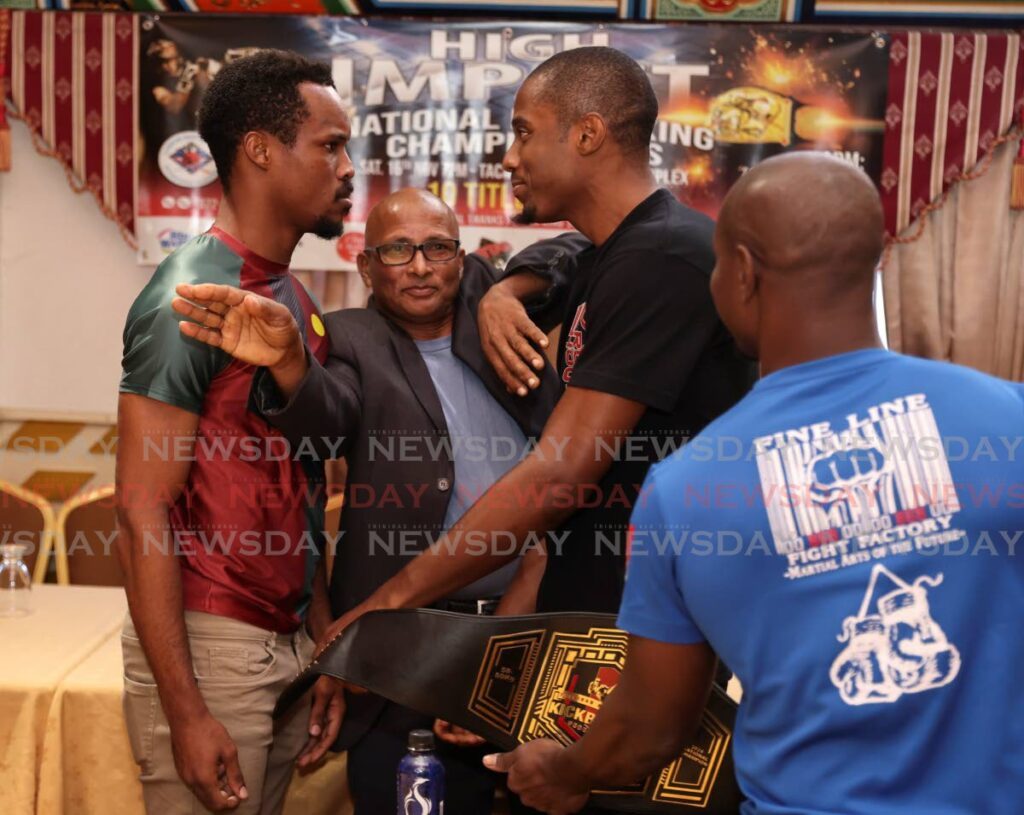 Fighters Joshua James, left, and Ronaldo Diaz are parted by TT Kickboxing Federation president Bharrath Ramoutar, at a media conference on October 15 launching the National Kickboxing Championships, at China Palace, Ellerslie Plaza, Maraval. - Photo by Jeff K Mayers