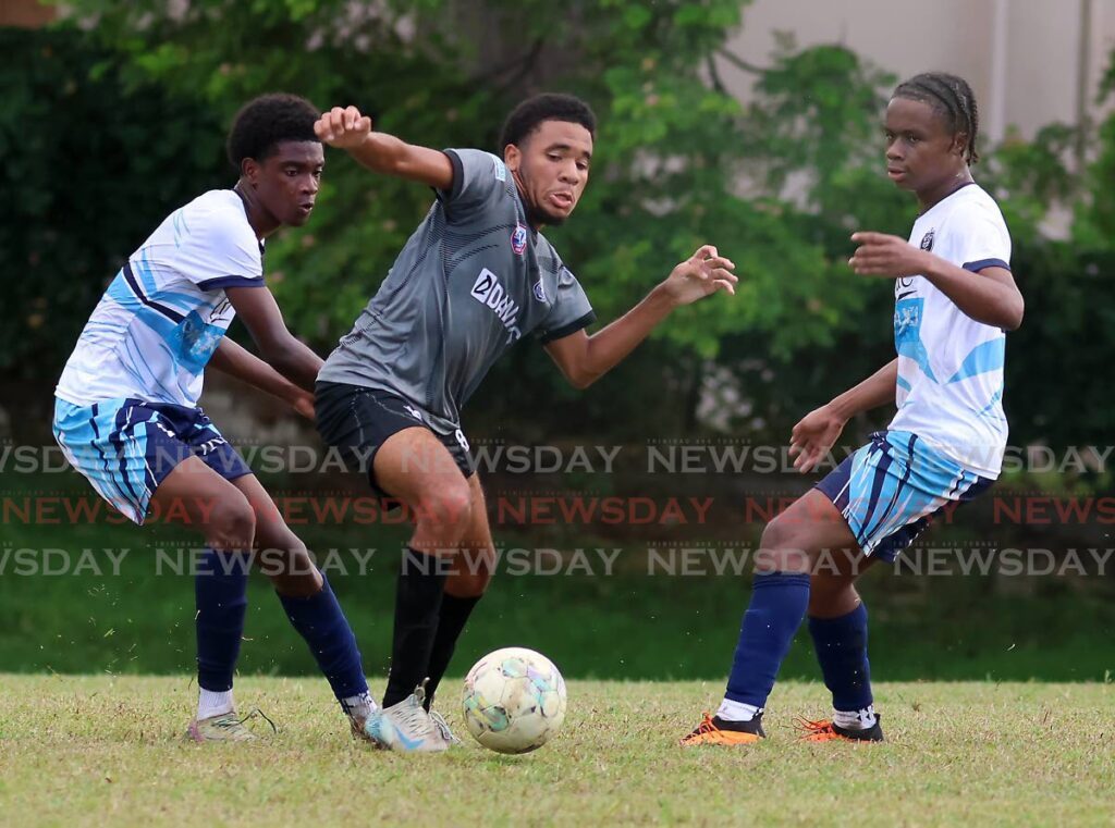 Naparima College’s Jerrel Cooper (C) tries to gain possession of the ball against pressure from Queen’s Royal College players during their SSFL Premiership Division match, on October 16, 2024 at Lewis Street Recreation Grounds, San Fernando. - Photo by Roger Jacob