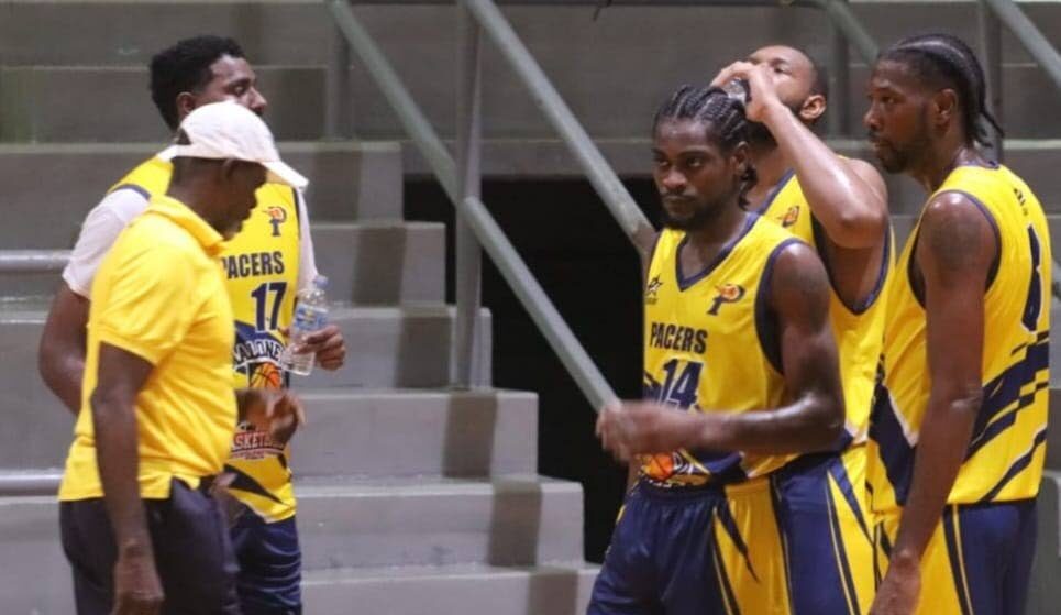 Coach Christopher Jackson Charles (L) talks things over during a huddle with his Maloney Pacers team in an Anomaly Basketball tournament match. - Photo courtesy Anomaly Basketball