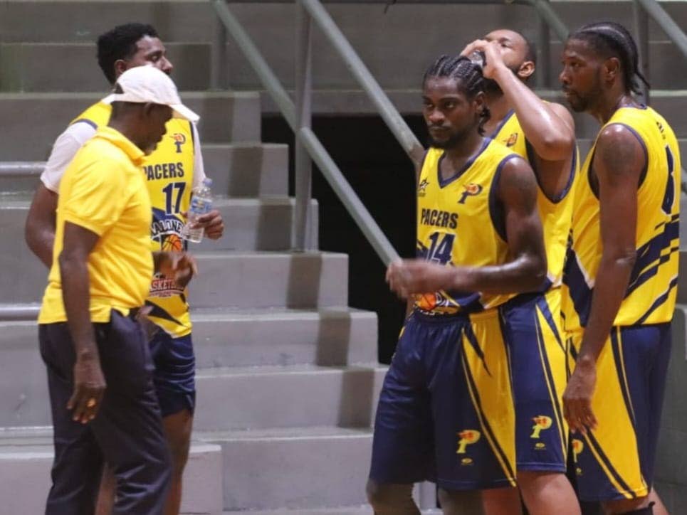 Coach Christopher Jackson Charles (L) talks things over during a huddle with his Maloney Pacers team in an Anomaly Basketball tournament match. Photo courtesy Anomaly Basketball - 