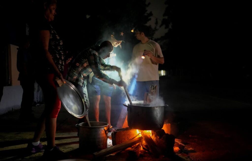 Residents prepare soup over an open fire during a blackout following the failure of a major power plant in Havana, Cuba, on October 19. - AP PHOTO 