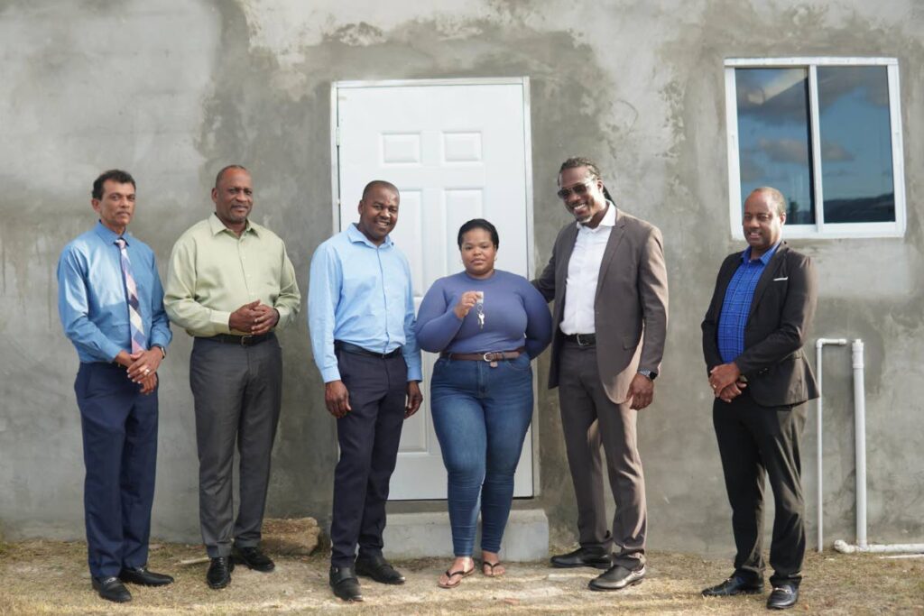 A Jacob Hill resident receives the keys to her new starter home in Wallerfiled on October 18. From left, are, Land Settlement Agency (LSA) chief executive officer Hazar Hosein, LSA chairman Allan Meiguel, MP Foster Cummings, Minister in the Ministry of Housing Adrian Leonce and LSA committee member Edmund Phillips. - Photo courtesy LSA