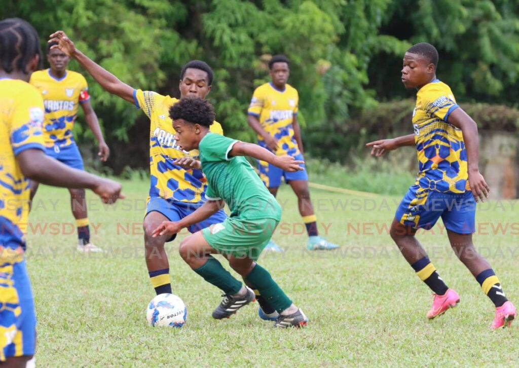 San Juan North Secondary’s Jamaludin Blandin (C) controls the ball against several Sepyside High School players during their Secondary Schools Football League premiership division match, on October 22, in San Juan.  - Photo by Angelo Marcelle