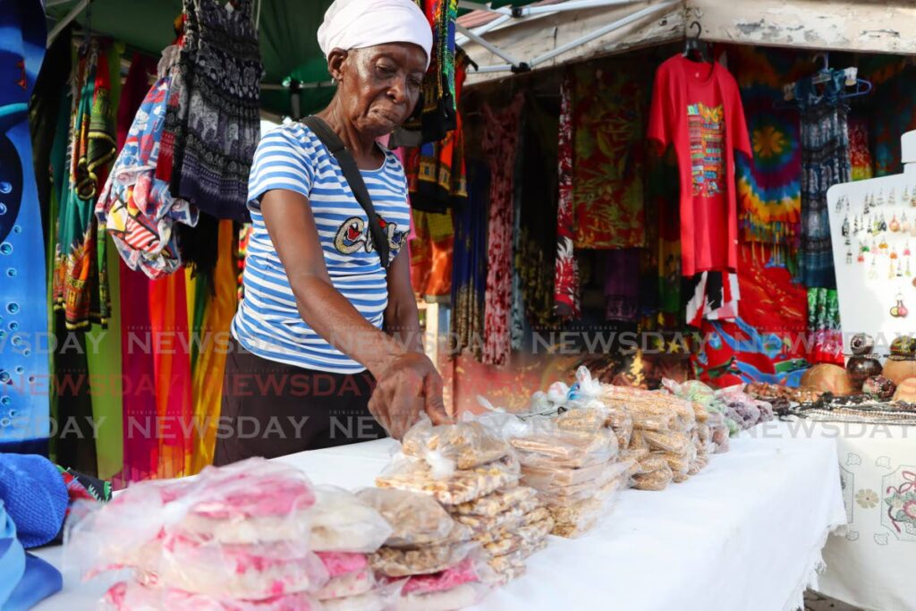 Vendor Patsy Thompson packs her bene sticks at Store Bay Beach Facility, October 23. - Photo by Ayanna Kinsale