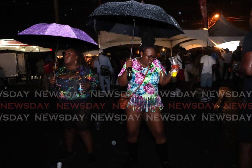 Patrons enjoy themselves in the rain at Army Fete, Cyd Gray Stadium, Roxborough on October 24. - Photo by Ayanna Kinsale