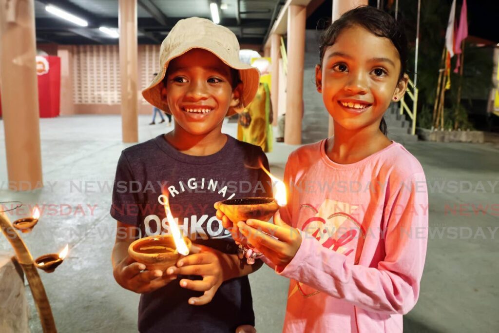 Six-year-old Tallah, left, and Yasmin Pollard, seven, with deyas at the Divali Nagar on October 24.  - Photo by Lincoln Holder 