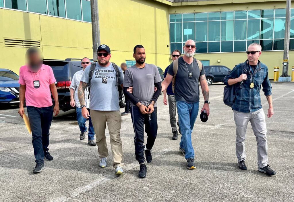 US marshals and agents from TTPS and the US Diplomatic Security Service escort Farzan Mohammed at the Piarco airport for his extradition to the US for crimes against children. - Photo courtesy US Embassy