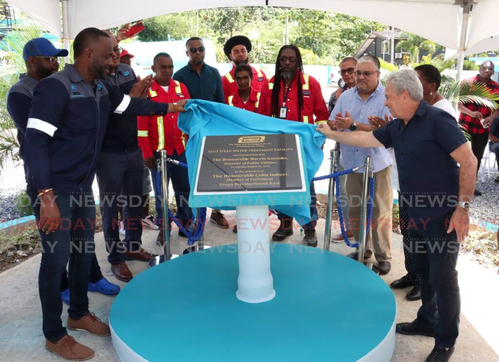 Minister of Public Utilities Marvin Gonzales and MP for Diego Martin North/East Colm Imbert unveil the plaque with officials of WASA at the commissioning ceremony for the New Saut D'eau Water Treatment Facility, Maraval on October 26. - Photo by Faith Ayoung