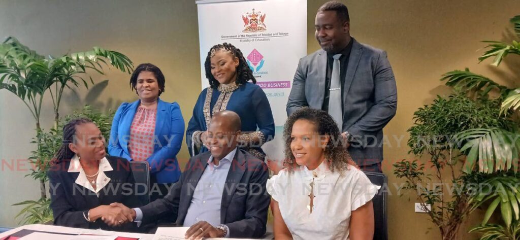 Dr Wayne Frederick (seated, centre) greets Ministry of Education PS Jacqueline Charles, while he is flanked by wife Simone Frederick. Standing behind are PS Simon Williams, from left, Education Minister Dr Nyan Gadsby-Dolly and project co-ordinator Ian Haywood. - Photo by Sean Douglas