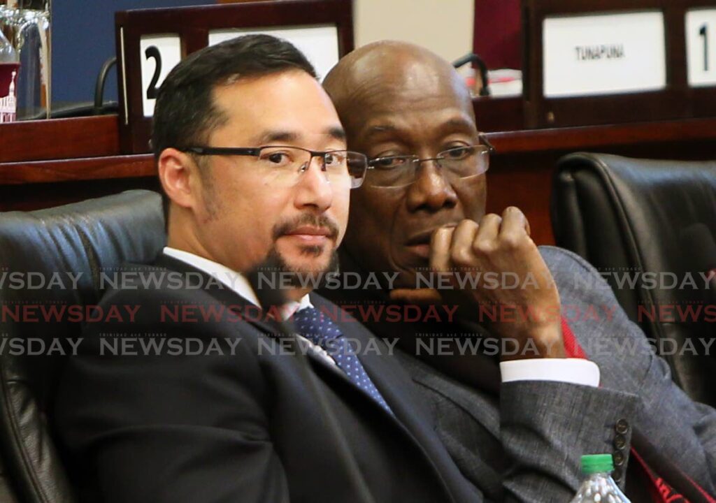 Prime Minister Dr Keith Rowley, right, chats with MP Stuart Young in the Lower House in 2018. - File photo