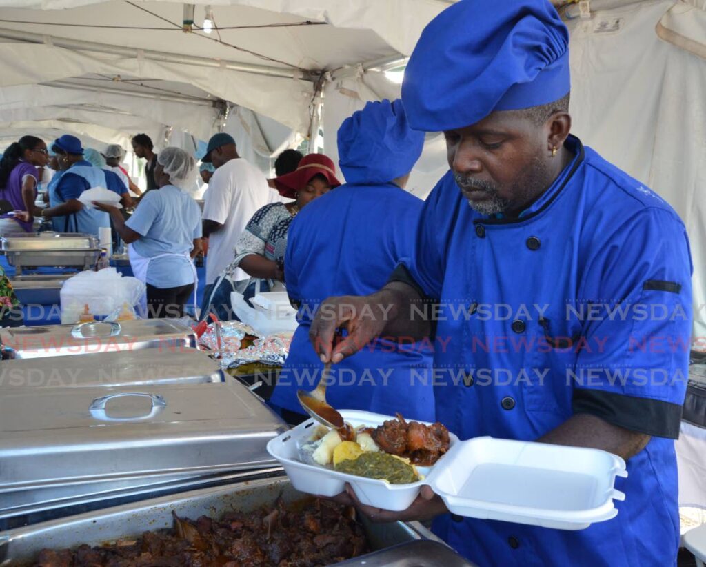 Blue Food chef Kevin Charles places a meal into a container at last year's festival. - 