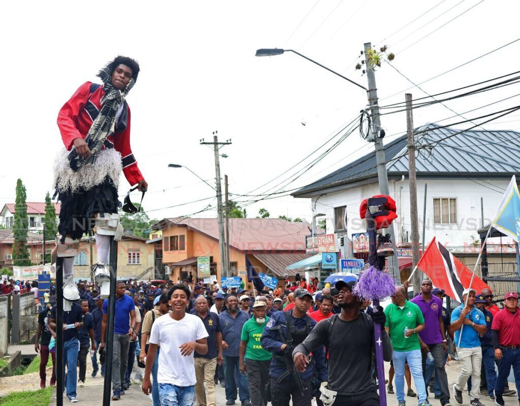 A moko jumbie towers over participants in this year’s Labour Day march to Charlie King Junction, Fyzabad.  - File photo