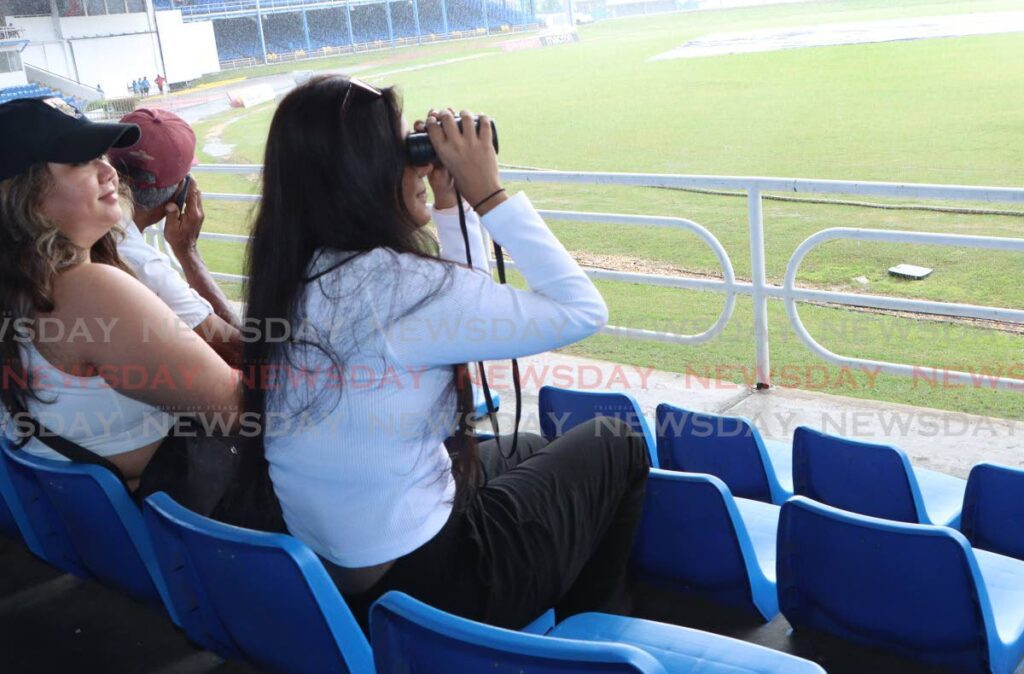 A cricket fan looks through her binoculars during the first day a Test match between West Indies and South Africa, on August 7, 2024 at the Queen's Park Oval, St Clair.  - File photo by Angelo Marcelle